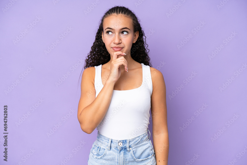 Young woman isolated on purple background thinking an idea while looking up Young woman isolated on purple background thinking an idea while looking up
