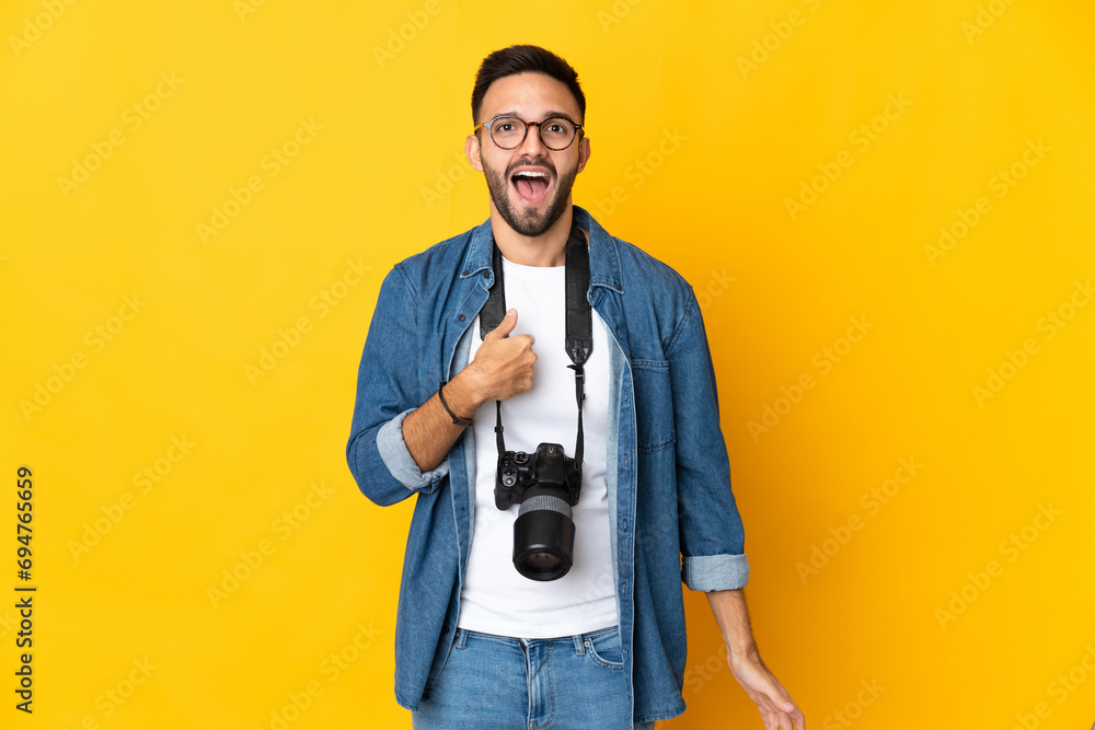 Young photographer girl isolated on yellow background with surprise facial expression Young photographer girl isolated on yellow background with surprise facial expression