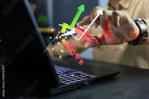 Stock exchange concept with investors decide to use scissors to cut or eliminate the loss portion of the red chart to maintain costs or prevent further loss in the market on laptop screen