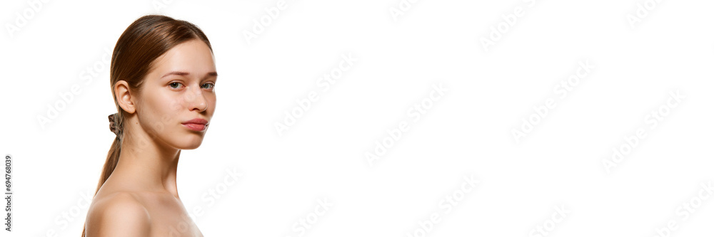 Banner. Portrait of beautiful young woman with bare shoulders, well-kept spotless skin looking at camera isolated white background. Banner. Portrait of beautiful young woman with bare shoulders, well-kept spotless skin looking at camera isolated white background.