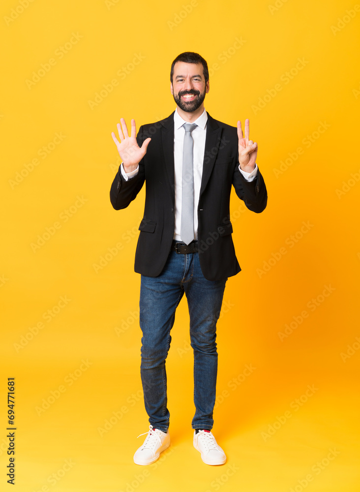 Full-length shot of business man over isolated yellow background counting seven with fingers Full-length shot of business man over isolated yellow background counting seven with fingers