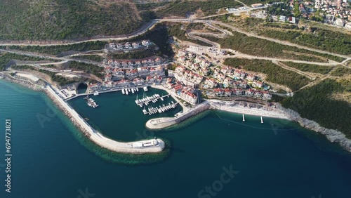 Aerial view of Lustica Bay, Adriatic sea, Montenegro. Top view of buildings, Harbor Marina with moored boats and yachts and lighthouse against the backdrop of mountains. New modern luxury resort. photo