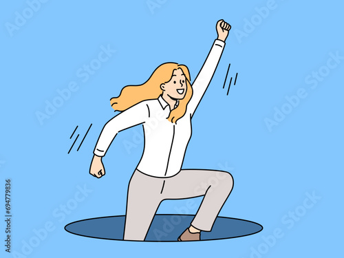 Ambitious business woman jumps out of hole in ground with hand raised up, wanting to achieve success. Ambitious businesswoman in pose superhero ready to help colleagues in solving corporate problems