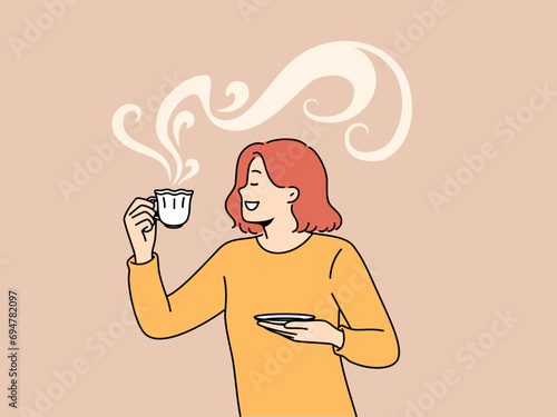Woman drinks aromatic coffee from beautiful mug and smiles enjoying taste of hot drink. Girl loves coffee or tea, which allows to refresh herself and gain strength before hard day at work.