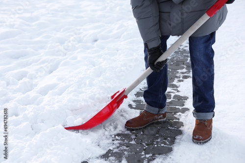 Fotografia Man removing snow with shovel outdoors, closeup
