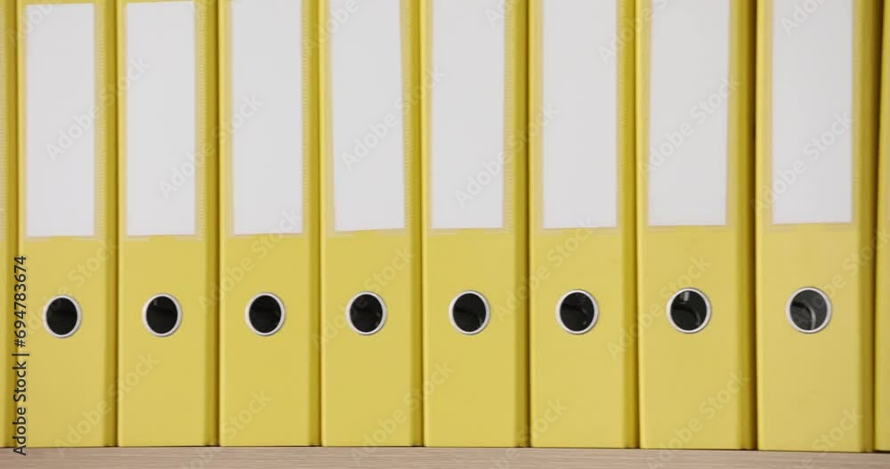 Yellow folders stand in a row, close-up. Stationery, office supplies, slowmotion Yellow folders stand in a row, close-up. Stationery, office supplies, slowmotion