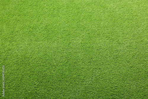 Green artificial grass as background, top view