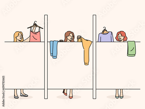 Women change clothes in stores changing room, standing behind screen, and choose clothes before purchasing. Shopaholic girls visiting fashion boutique try on dresses to choose best