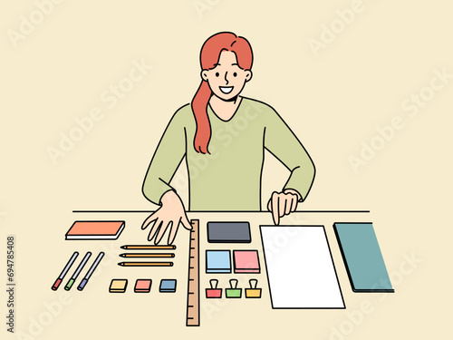 Perfectionist woman with OCD syndrome puts things in order on desktop and gets pleasure from perfectly placed stationery items. Girl with OCD disease smiles when she sees order in workplace