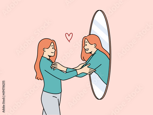 Woman hugs own reflection in mirror demonstrating narcissism and high self-esteem. Girl stands near mirror and rejoices at transformation of appearance after changing image and buying new clothes.