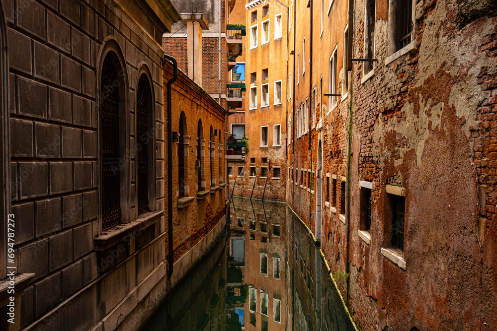 Narrow canal with reflection in Venice, Italy
