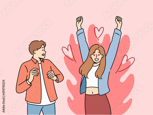 Excited woman is in love with man who is scared because of excessive passion from fan. Guy looks excitedly at girlfriend feeling great passion and sympathy for boyfriend or fiance.