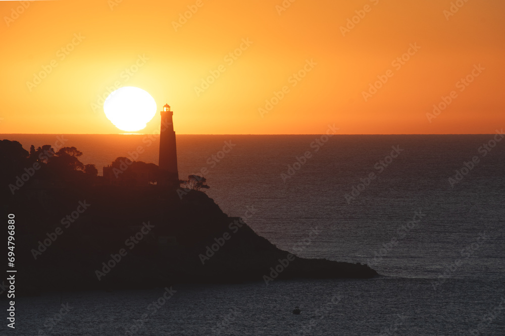 Coucher de soleil en bord de mer sur le phare de la presqu'île du Cap Ferrat depuis le Cap de Nice