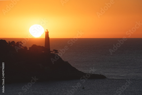 Coucher de soleil en bord de mer sur le phare de la presqu   le du Cap Ferrat depuis le Cap de Nice
