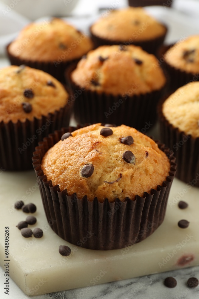Delicious sweet muffins with chocolate chips on table, closeup Delicious sweet muffins with chocolate chips on table, closeup