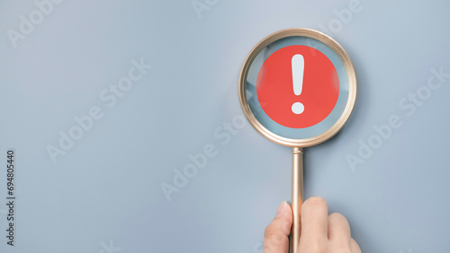 Attention caution warning concept. Magnifying glass focus on red page with exclamation error mark for important alert signal, Hazard, risk ,danger background with copyspace. photo