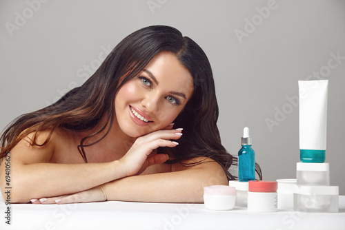 Valokuva Studio shot of beauty female portrait on many various moisturizers and skin care products with rejuvenation effect