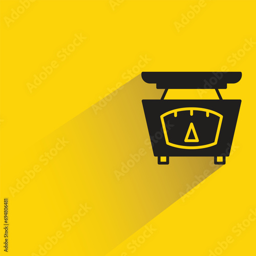 kitchen weight scale with shadow on yellow background