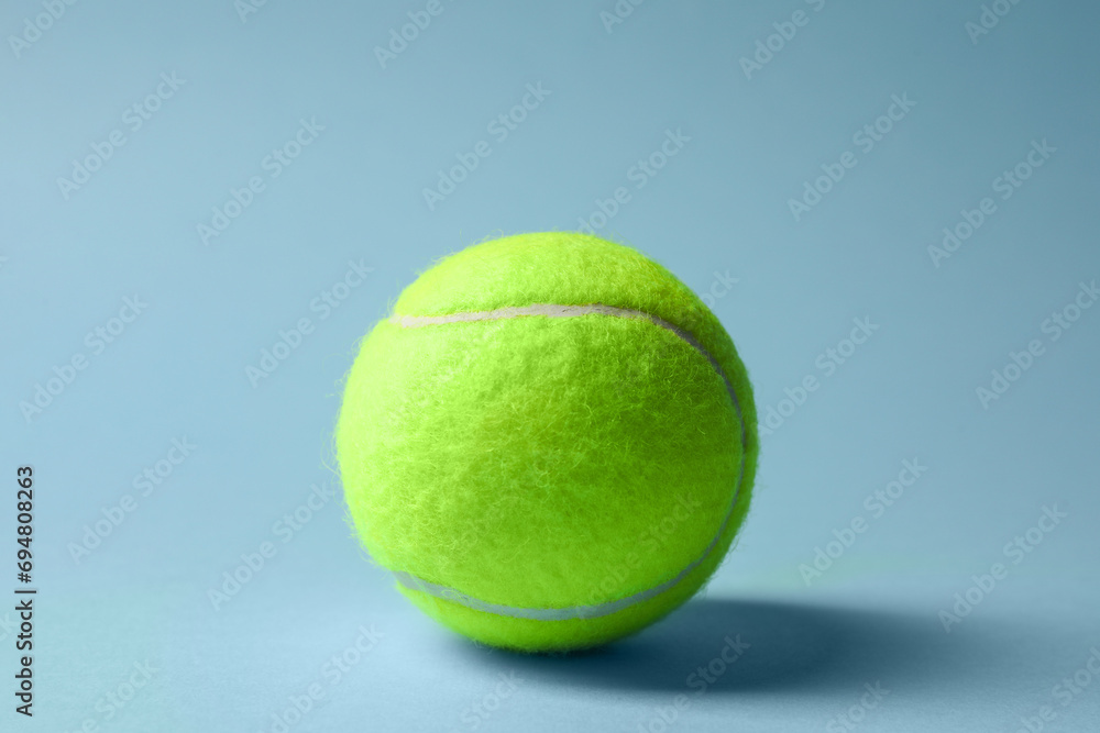 One tennis ball on light blue background