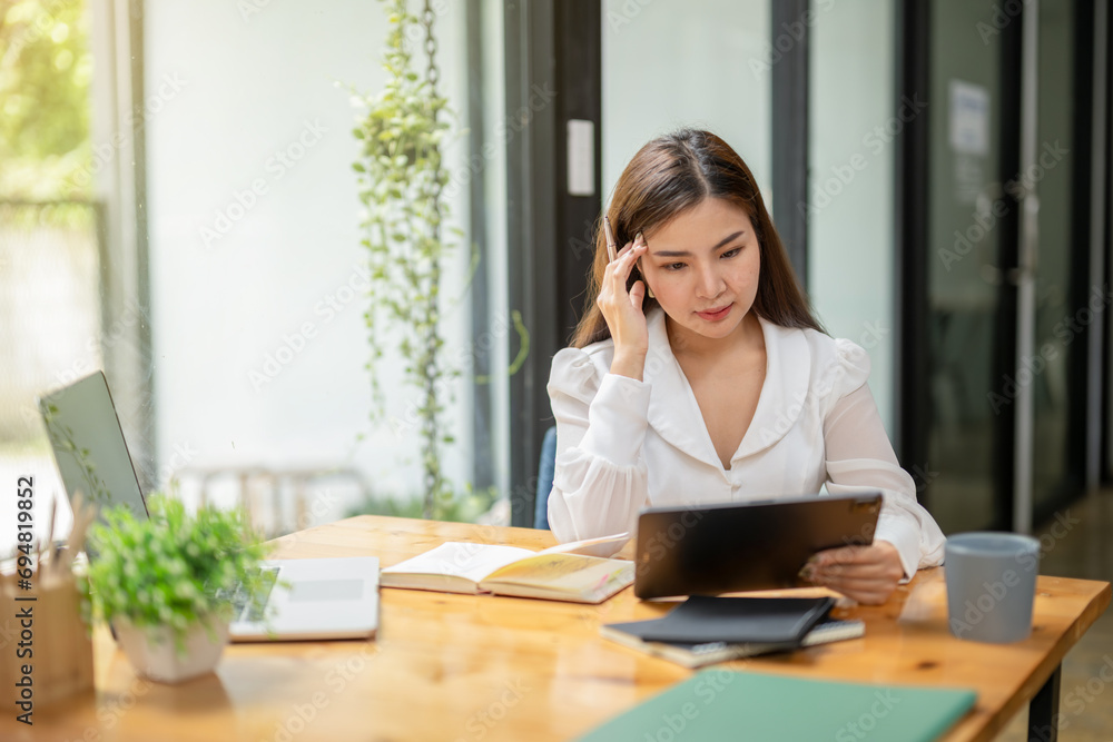 Asian businesswoman working using digital tablet thinking and analyzing work data plan, Verify digital documents Asian businesswoman working using digital tablet thinking and analyzing work data plan, Verify digital documents