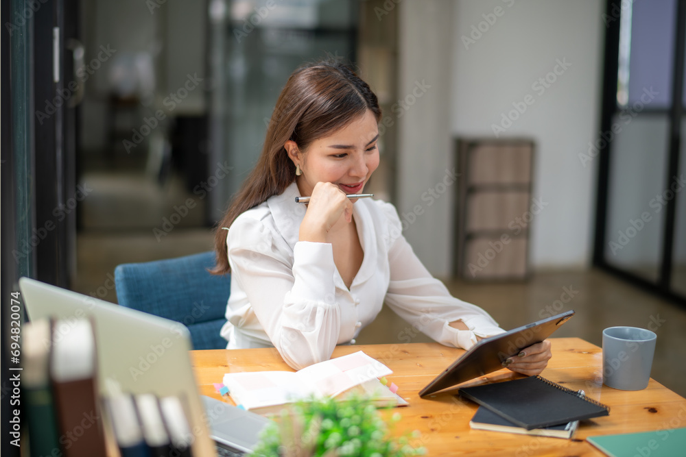 Asian business woman working using a digital tablet. Think, analyze data and plan work. Asian business woman working using a digital tablet. Think, analyze data and plan work.