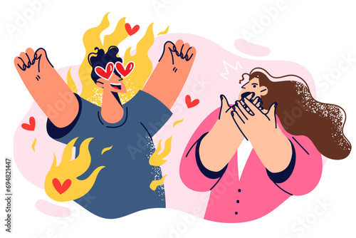 Loving man scares woman with excessive excitement and emotionality, standing among flames