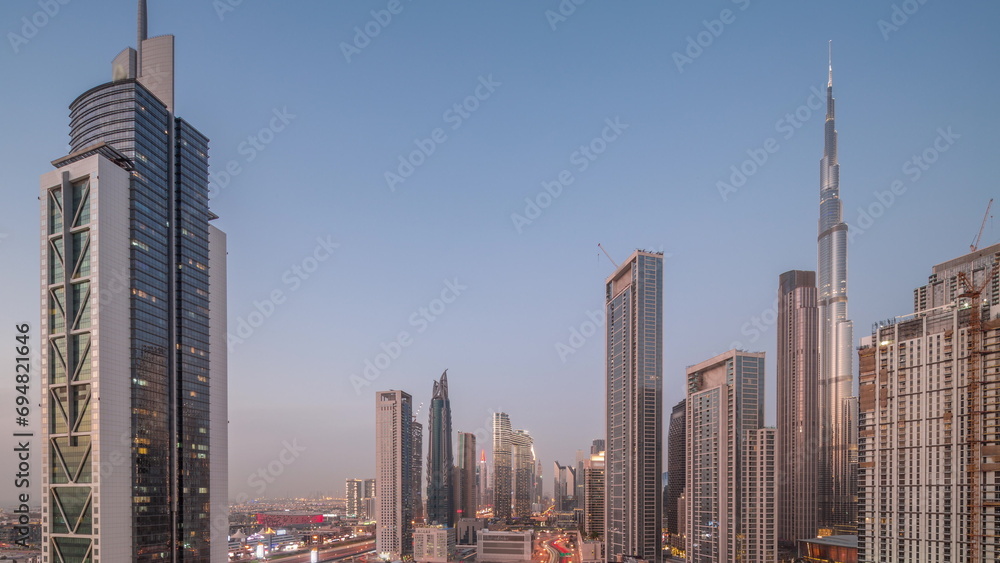 Fototapeta premium Aerial view of Dubai Downtown skyline with many towers day to night timelapse.