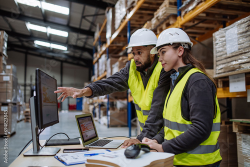 Warehouse manager talking with logistics employee in warehouse, planning transport of products, talking shipping process. photo