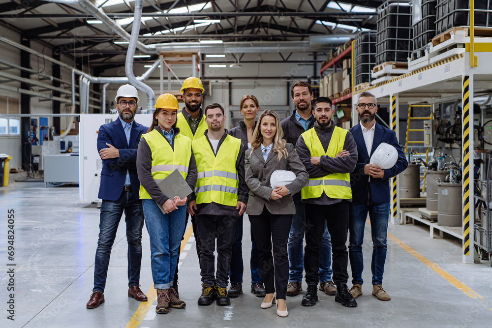 Full team of warehouse employees standing in warehouse. Team of workers, managers, female director in modern industrial factory, heavy industry, manufactrury.
