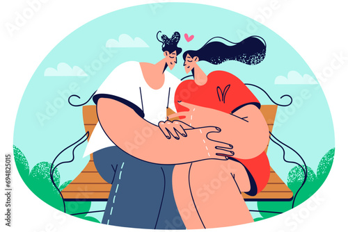 Happy couple sitting on bench hugging