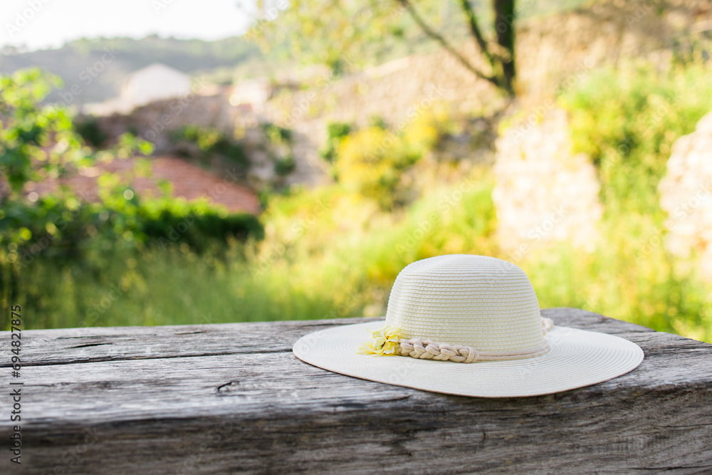Summer nature background. Braided straw hat on bench in garden. spring season. Rustic composition nature. Relax voyage time. Copy space and mock up place for text Summer nature background. Braided straw hat on bench in garden. spring season. Rustic composition nature. Relax voyage time. Copy space and mock up place for text