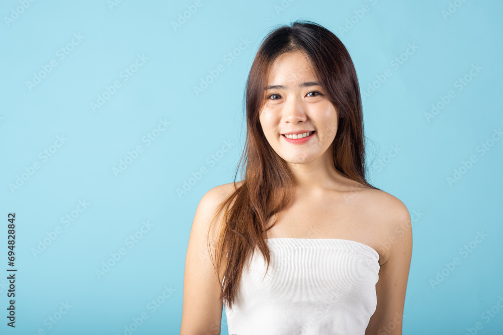 Beauty and Skin care. Asian woman with beauty face touching healthy facial clean skin studio shot isolated on blue background, Beautiful female model smiling with natural makeup and healthy face Beauty and Skin care. Asian woman with beauty face touching healthy facial clean skin studio shot isolated on blue background, Beautiful female model smiling with natural makeup and healthy face