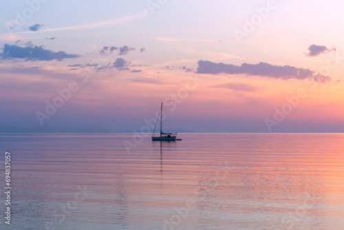 Sailing boat on calm ocean under sky photo