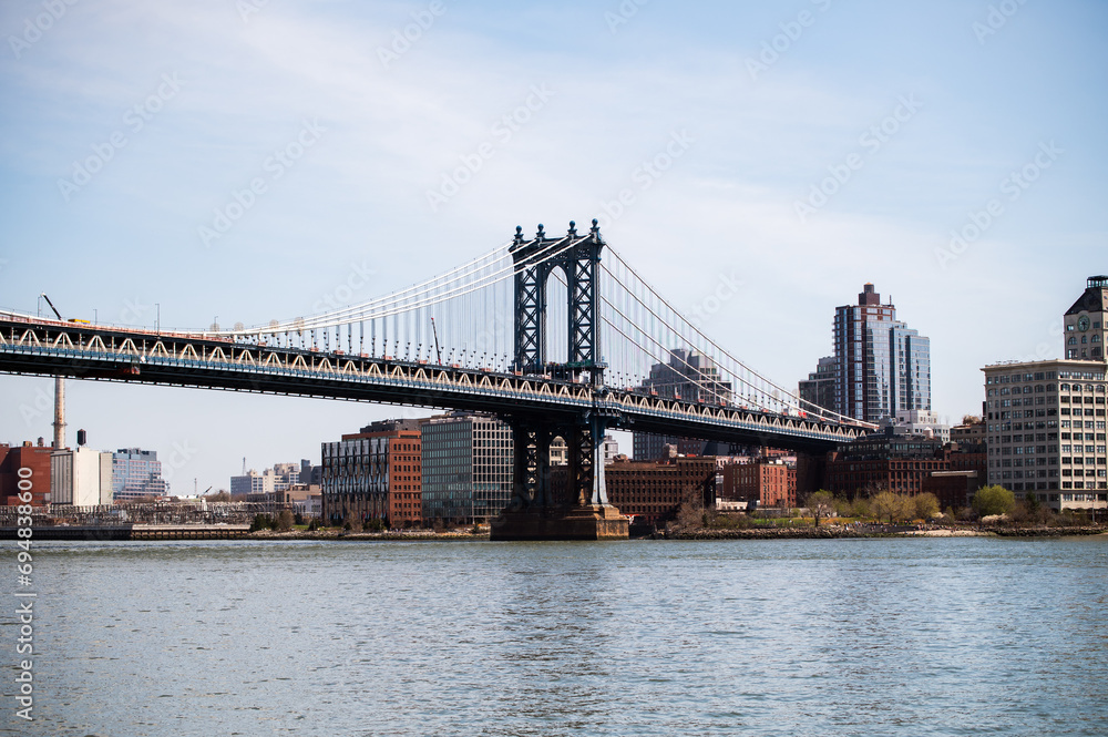 Elegant Manhattan Bridge stretching under clear blue sky Elegant Manhattan Bridge stretching under clear blue sky