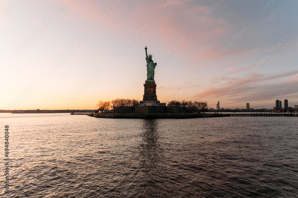 Statue of Liberty on shore under sundown sky Statue of Liberty on shore under sundown sky