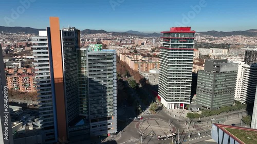 Aerial view of Barcelona at midday with high skyscrappers and wide panorama of the city on the background. Landscape and architecture. Drone flying over Forum Park and Diagonal Mar. Spain, Europe. photo