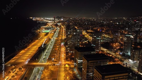 Aerial view of Barcelona at night with high skyscrappers and coast line. Landscape and architecture. Drone flying over Forum Park and Diagonal Mar. Spain, Europe. photo