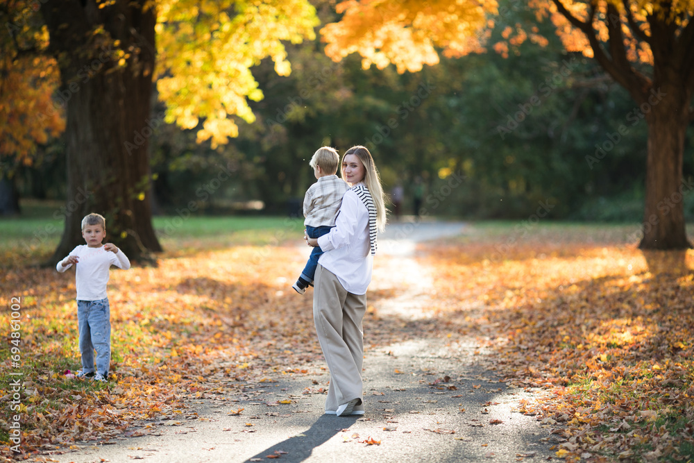 Fototapeta premium Mothers day, love family. Family on autumn walk in nature outdoors. Mother and child with hugging tenderness