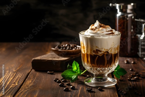 Cold coffee with vanilla ice cream in a glass on a black wooden background. Irish coffee delight.