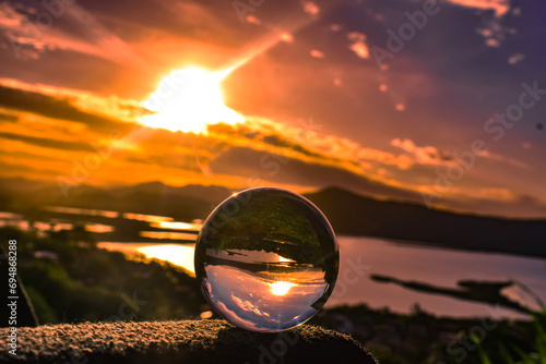 Incrível pôr do sol refletido numa lente de esfera. photo
