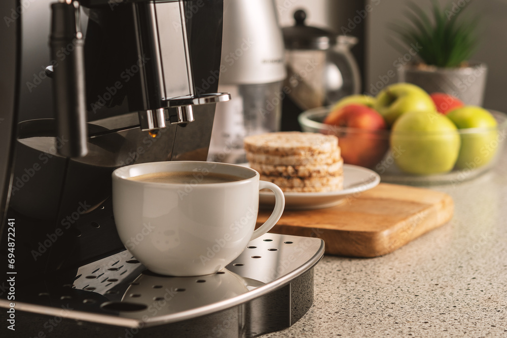 Modern espresso coffee machine with a cup in interior of kitchen closeup. Modern espresso coffee machine with a cup in interior of kitchen closeup.