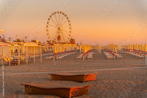 View of ferris wheel and sunshades on the Lido on Rimini Beach at sunrise, Rimini, Emilia-Romagna photo