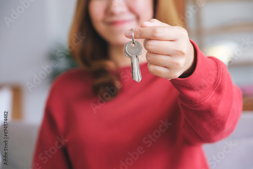 Closeup image of a young woman holding the keys for real estate concept photo