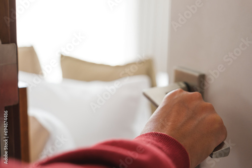 Closeup image of a hand opening bedroom door