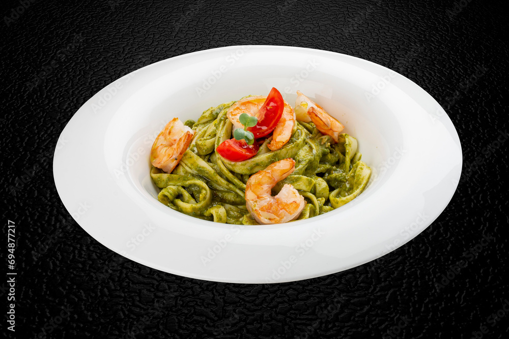 Fettuccini with shrimp and pesto sauce. Isolated image Fettuccini with shrimp and pesto sauce. Isolated image