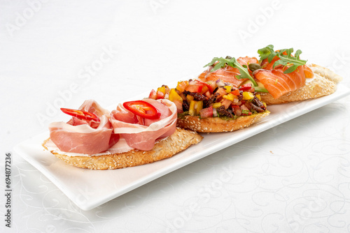 Bruschetta set, with salmon, prosciutto and vegetable salsa. Isolated image