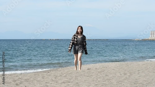 砂浜を歩く若い女性