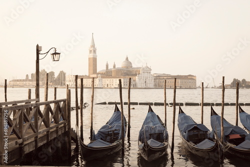 Gondolas moored on the Lagoon, San Giorgio Maggiore beyond, Riva degli Schiavoni, Venice, UNESCO World Heritage Site, Veneto, Italy photo