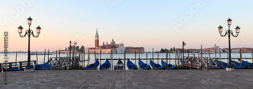 Gondolas moored on the Lagoon, San Giorgio Maggiore beyond, Riva degli Schiavoni, Venice, UNESCO World Heritage Site, Veneto, Italy photo