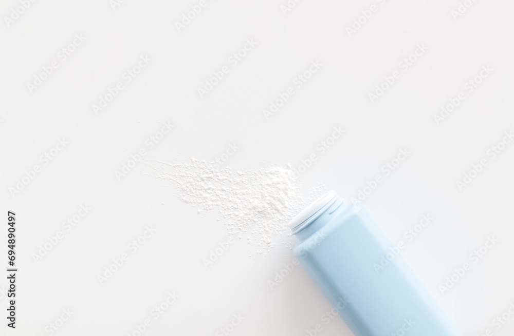 Spilled baby talcum powder. Container with powder for baby body care Spilled baby talcum powder. Container with powder for baby body care